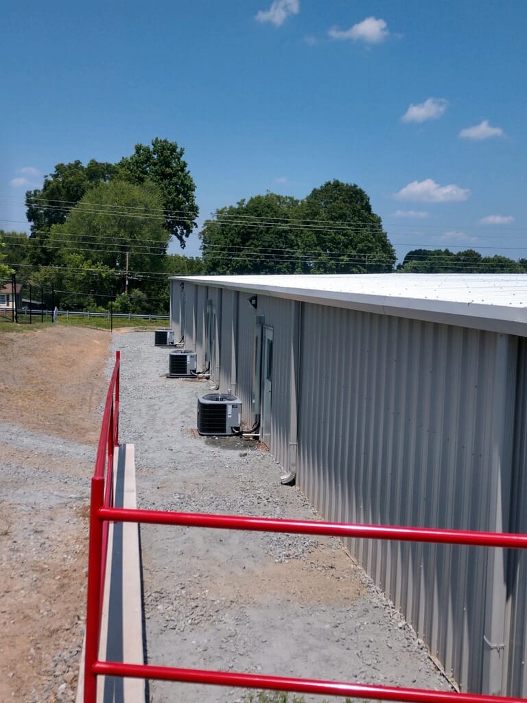 three HVAC units installed behind building